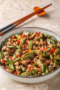 Kızarmış Çin fasulyesini gevrek domuz eti, dolma biber, sarımsak ve zencefil ile karıştırın. Dikey