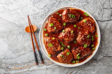 Lezzetli, yumuşak ve ekşi domuz pirzolası masanın üzerindeki tabağa yakın acı sosla kaplanır. Yukarıdan yatay üst görünüm