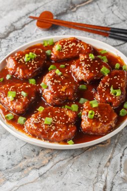 Tatlı ve ekşi domuz pirzolası ya da Çin usulü Çin pirzolası. Tabağın üzerine yakın plan Çin yemeği. Dikey