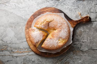 İtalyan Muhallebi Keki veya Torta Nua, minimalist görünüşü ve masadaki ahşap tahtaya yakın aroması ile bilinen bir tatlıdır. Yukarıdan yatay üst görünüm