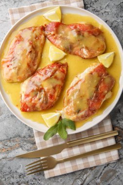 Tavuk saltimbocca çıtır çıtır, altın renginde ve limon tava sosuyla yıkanmış masanın üzerindeki tabağa yakın çekim. Yukarıdan dikey üst görünüm