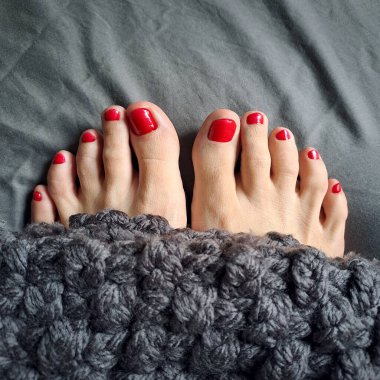 Kırmızı ojeli iki kadın parmağı resmi. Yakından.