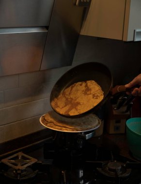 Mutfaktaki fırında krep pişirme zamanı geldi çattı. Tavadaki krepleri istifleme zamanı.