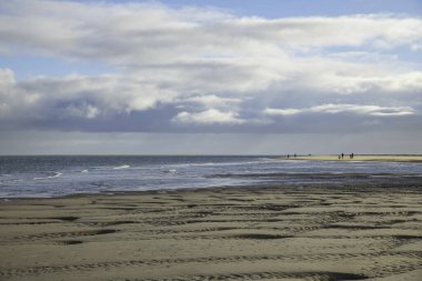 De Koog, Hollanda, 06-dec-2022: Tekel adasının sahillerinde yürüyen insanlar, bu ada çöl gibi ve yaz boyunca çok turistik bir ada.