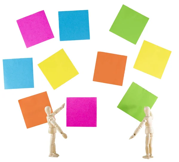 two wooden puppet man with wall full of post it papers on white background