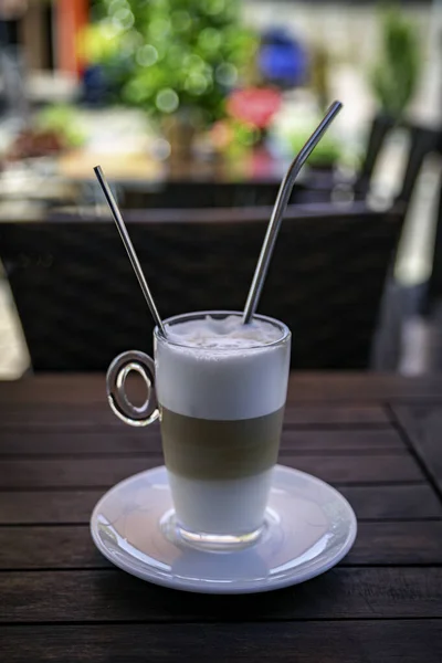 Latte Macchiato Szklance Białym Spodzie Metalową Słomką Metalową Łyżką Kolorowym — Zdjęcie stockowe
