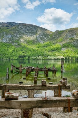 Slovenya, Triglav Ulusal Parkı 'ndaki Bohinj Gölü' nde eski bir ahşap iskelenin, dağların ve güzel doğanın kalıntıları.