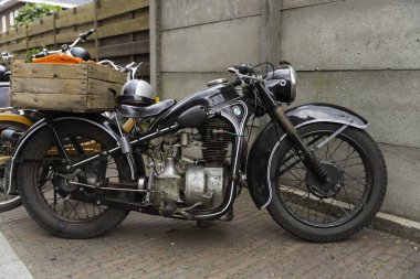 Lunteren, 25-aug-2023: Hollanda sokaklarında orijinal kasklı çok eski bir BMW motosiklet.