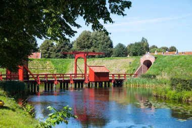 Hollanda 'nın Groningen kentindeki Bourtange kalesinin etrafındaki savunma duvarında geçit ve asma köprüye sahip iskele.