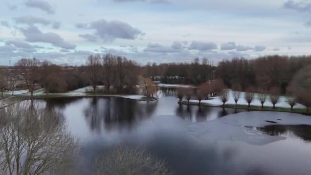 在Hellevoetsluis公园里的一个池塘 前景是长有花冠的柳树 冬季无人驾驶电影中的草坪上覆盖着一层小雪 — 图库视频影像