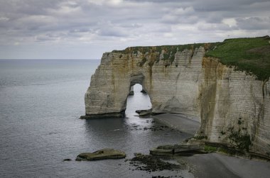 Okyanus kenarındaki yüksek, dik kireçtaşı uçurumlarının manzaralı bir fotoğrafı.