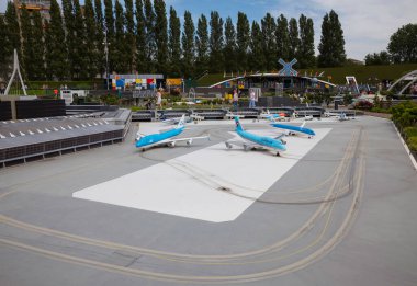 Haque, Holland, 9-07-2024:, Hollanda 'nın dört bir yanından gelen Madurodam park binalarının turistik bir eğlencesi olarak Hollandalı ünlü havaalanı schiphol kopyalarının tadını çıkaran ziyaretçiler.