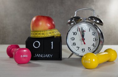 A composition symbolizing New Years resolutions with dumbbells, an apple, a tape measure, and a clock. Ideal for illustrating fitness goals and healthy lifestyles. clipart