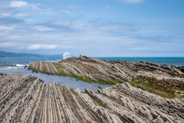 Itzurun sahilindeki kayalıklara ya da İspanya 'daki Zumaia plajlarına dalgalar çarpar.