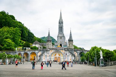 Lourdes, Fransa, 08-Haziran-2025: Birçok hacı güzel bir bahar günü, Avrupa 'da, Lourdes Leydisinin Sığınağını ziyaret etti.