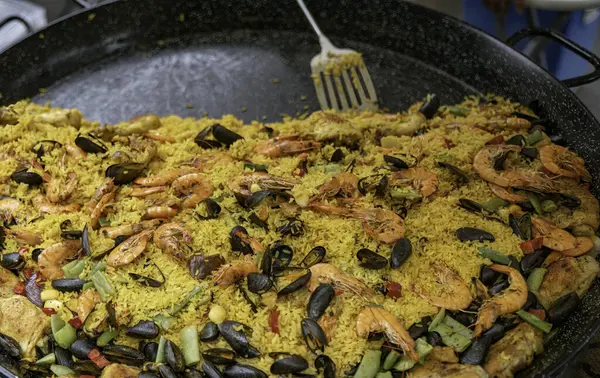 Safran katkılı pirinç, deniz ürünleri, taze tavuk ve taze sebzelerle yapılan enfes bir geleneksel İspanyol paella büyük bir tavada servis edilir. Toplama ve mutfak sunumları için mükemmeldir..