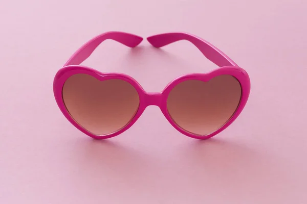 ピンクの背景にハート型のサングラス — ストック写真