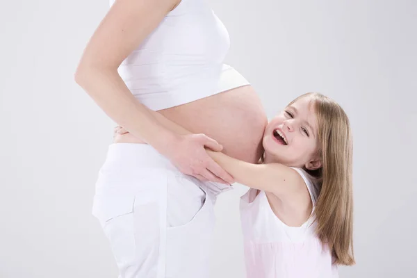 Malá Dívka Objímání Těhotná Matka Studio Shot — Stock fotografie