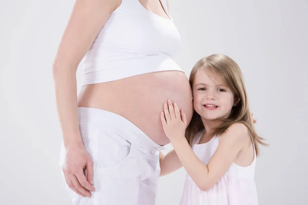 Niña Abrazando Madre Embarazada Disparo Estudio — Foto de Stock