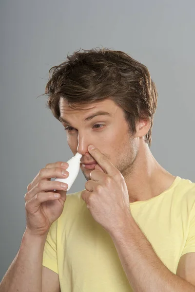 Retrato Homem Usando Spray Nasal Fundo Cinza — Fotografia de Stock