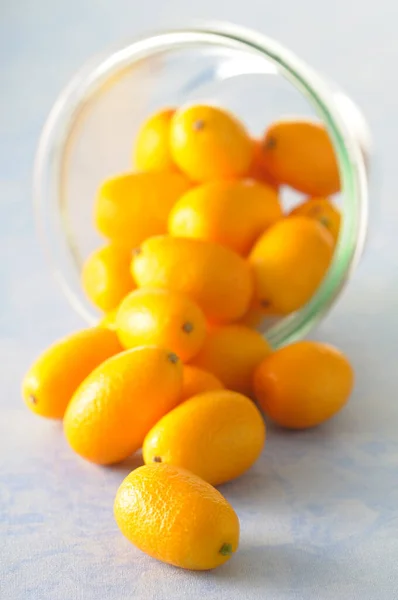 Close Bowl Kumquats Spilling Blue Background Studio Shot — Stock Photo, Image