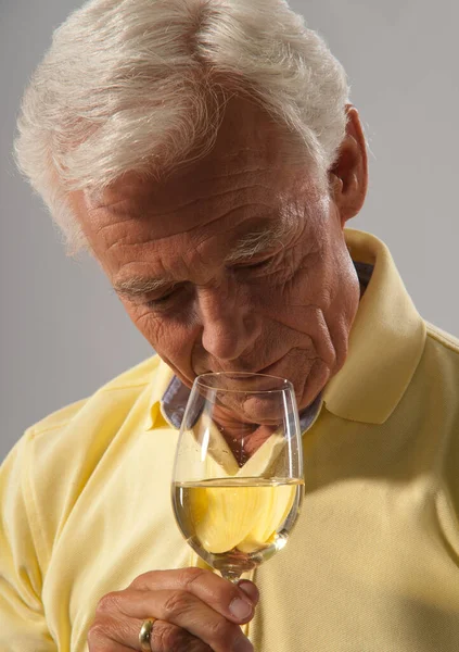 Älterer Mann Riecht Wein Auf Grauem Hintergrund — Stockfoto