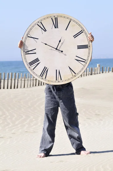 Αγόρι Κρατώντας Ένα Μεγάλο Ρολόι Στην Παραλία — Φωτογραφία Αρχείου