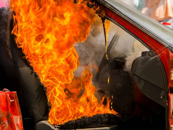 Burning broken red car in a fireman show