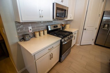 Mikrodalgası, gaz ocağı ve buzdolabı olan modern mutfak.