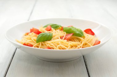 Beyaz tabakta domatesli taze İtalyan makarnası.