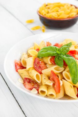 Beyaz tabakta domatesli taze İtalyan makarnası.