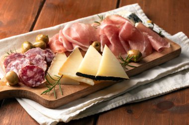 Platter of sliced prosciutto crudo, salami, pecorino and gorgonzola, delicious italian foods