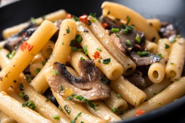 Macaroni with herbs and champignons in bowl