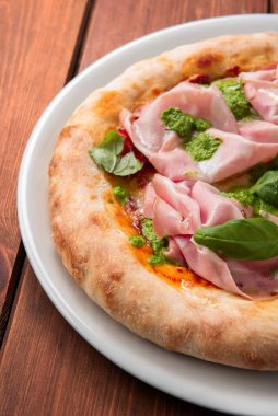 Oven baked pizza with ham and pesto