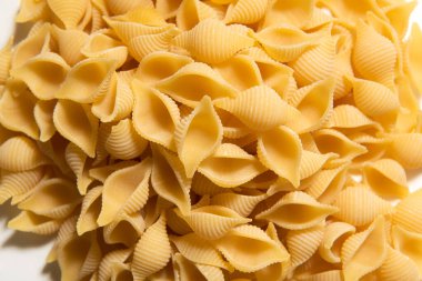 Pile of raw macaroni on white background