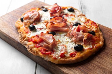 Italian pizza with prosciutto and olives