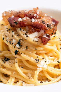 Lezzetli bukatini alla carbonara tabağı. Yumurtalı İtalyan makarnası, guanciale ve pecorino tarifi.
