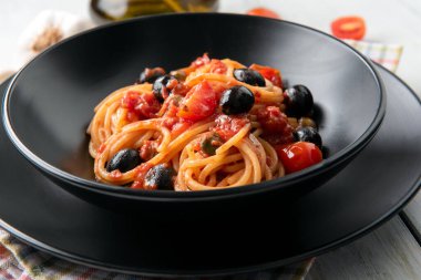 Bir tabak lezzetli spagetti puttanesca, tipik İtalyan yemeği.