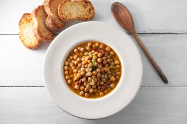 Ahşap masada nohut ve crostini ile lezzetli çorbanın yakın plan görüntüsü.