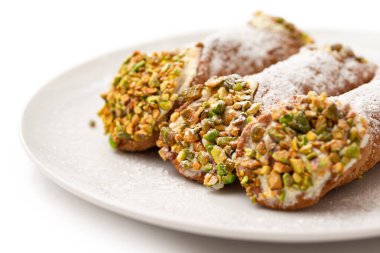 Beyaz arka planda izole edilmiş ricotta ve şam fıstıklı geleneksel Sicilyalı cannolo, İtalyan yemeği.