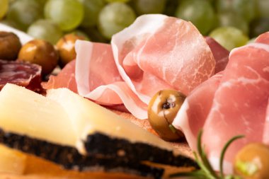 Ahşap tahtada servis edilen çeşitli mezelerin kırpılmış görüntüsü.