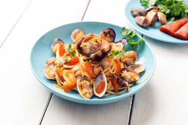 Lezzetli deniz ürünleriyle pişirilmiş makarna, mavi tabakta yemekler.  