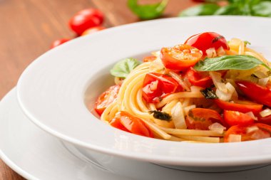 Bir tabak lezzetli spagetti, fesleğen, domates ve peynir, İtalyan yemeği.