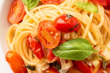 Bir tabak lezzetli spagetti, fesleğen, domates ve peynir, İtalyan yemeği.