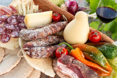 Pork salami, carasau, red wine and pecorino, typical sardinian products, rustic italian food