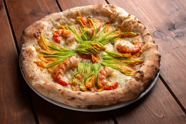 Delicious white gourmet pizza with zucchini flowers and shrimps, Italian food
