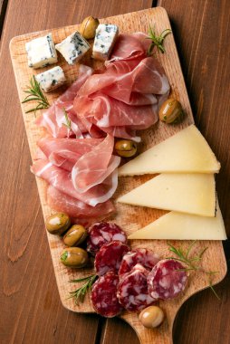 Yakın plan lezzetli dilimlenmiş peynir ve ahşap tabakta soslu et.