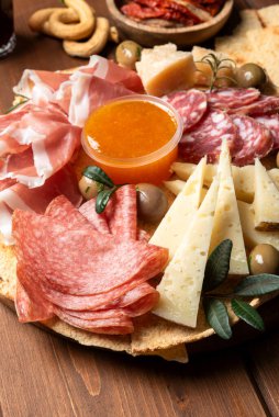 Yakın plan lezzetli dilimlenmiş peynir ve ahşap tabakta soslu et.