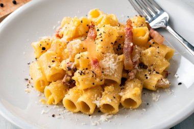Plate of delicious carbonara macaroni, a traditional roman recipe of pasta with egg sauce, guanciale and pecorino, italian food clipart