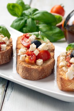 Üzerine mozzarella, zeytin, taze domates, fesleğen, kekik ve zeytinyağı, tipik İtalyan atıştırmalığı, Akdeniz diyeti...